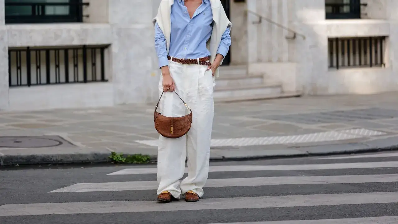 Damen-Outfit: Leinenhose kombiniert mit hellblauem Hemd, braunem Gürtel und Tasche.