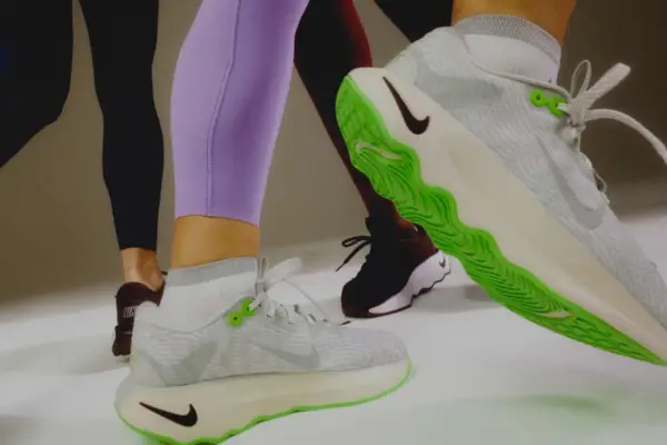 Sportliche Beine in Leggings und Sneakern. Ein Schuh mit leuchtend grüner Sohle zeigt, wie man Schuhe recyceln kann.